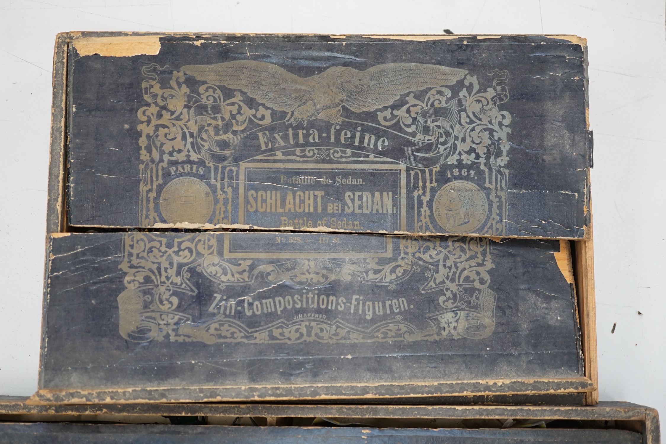 Two late nineteenth century wooden Haffner boxes of flat/semi-flat soldiers, contents believed to be primarily by Haffner; ‘Fight of Paris’ (set no.543) and ‘Battle of Sedan’ (set no.528)
